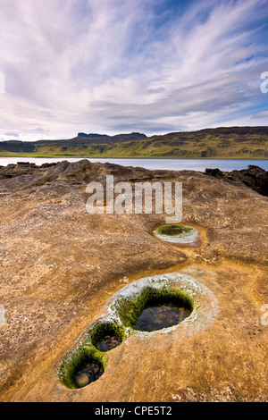 Piscine di roccia al di là di Laig Bay con un Sgurr nella distanza, Isola di Eigg, Ebridi Interne, Scotland, Regno Unito, Europa Foto Stock