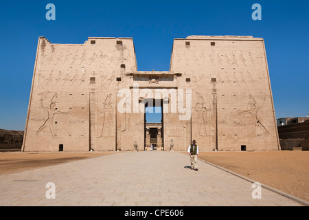 Uomo in piedi dall ingresso pilone del Tempio di Horus Edfu, Egitto, Africa Settentrionale, Africa Foto Stock