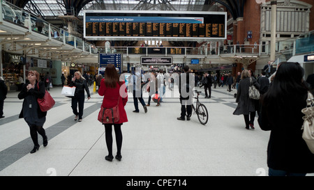 Passeggeri guardando alla scheda di partenza treno orario sull'atrio principale a Liverpool stazione ferroviaria in Londra England Regno Unito KATHY DEWITT Foto Stock