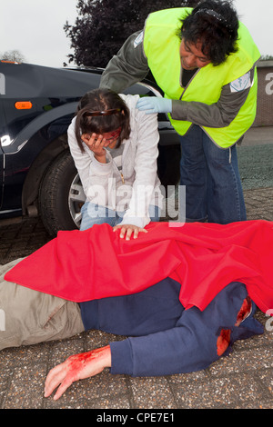 Donna malata e corpo morto dopo un incidente di automobile Foto Stock