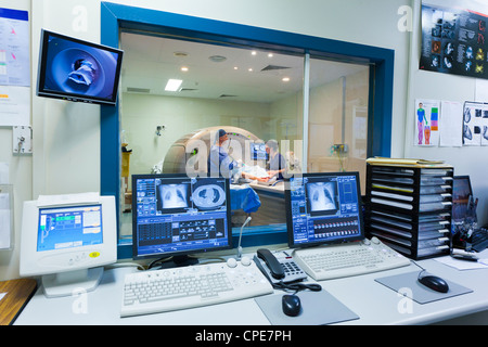 Macchina MRI e schermate con medico e infermiere Foto Stock