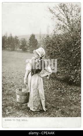 Cartolina edoardiana originale raffigurante una donna di campagna andando al pozzo, scena nostalgica rurale, inviato 4 maggio 1907, Regno Unito Foto Stock