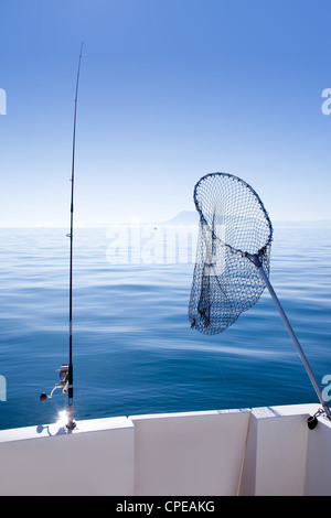 Barca da pesca asta e landing net nel mediterraneo mare blu Foto Stock