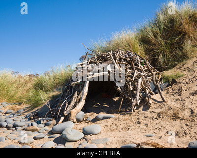 Un rifugio fatto di driftwood sulla spiaggia a Westward ho!, Devon, Inghilterra Foto Stock