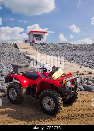 Un bagnino quad bike sulla spiaggia di Condino, Devon, Inghilterra. Foto Stock