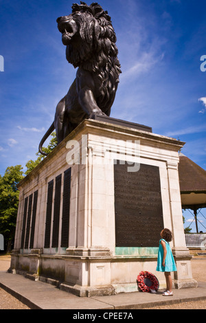 Un giovane bambino sta davanti al Maiwand Lion statua, Reading, Berkshire, Inghilterra, Regno Unito Foto Stock