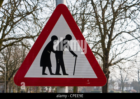 Un triangolo rosso cartello stradale di avvertimento del fragile pedoni probabilità di attraversare la strada. Foto Stock