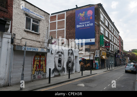 Pubblicità per 'Banglatown capitale Curry 2012' in Hanbury St, off Brick Lane, Londra copre la street art dall'artista Roa. Foto Stock