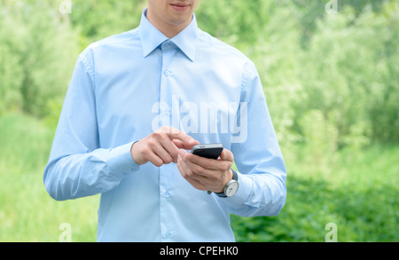 Giovane imprenditore utilizzando mobile smart phone nel parco. Foto Stock