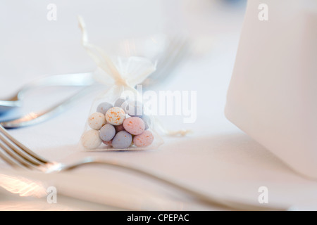 Un piccolo sacchetto di mussola di confetti come una tabella di decorazione su un tavolo di nozze Foto Stock