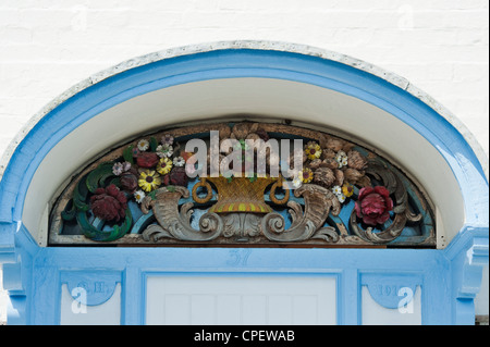 Cottage ornati porta anteriore in legno intagliato surround. Clovelly, North Devon, Inghilterra Foto Stock