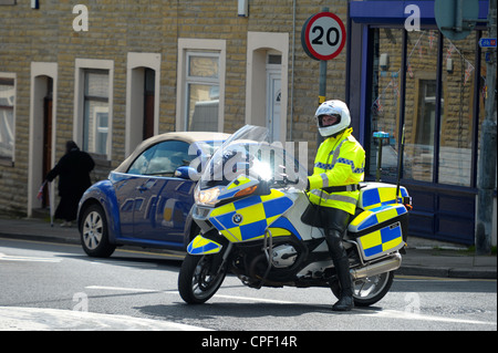 La polizia motociclista si ferma il traffico su una mini rotonda in attesa per la regina dell'Inghilterra corteo di automobili per drive through. Foto Stock