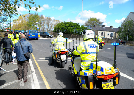 La polizia motocicli fermando il traffico e guidare la regina dell'Inghilterra "[s auto attraverso le strade di Burnley Foto Stock