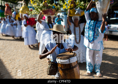 Un giovane seguace Candomblé suona tamburo durante la processione rituale in onore di Yemanjá ad Amoreiras, Bahia, Brasile. Foto Stock