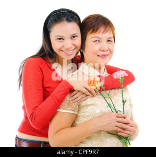 Asian madre holding chiodo di garofano con sua figlia isolati su sfondo bianco Foto Stock