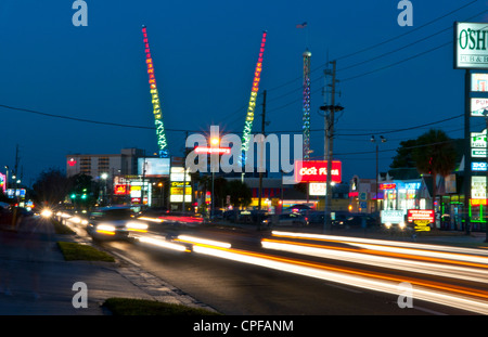 Twilight night shot dell'area turistica di International Drive in Orlando Florida con colorati di traffico e bungee jumping poli Foto Stock