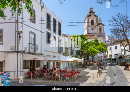 Street cafe su Rua Silva Lopes nella Città Vecchia (Cidade Velha) con l'Igreja de Santo Antonio dietro, Lagos, Algarve, PORTOGALLO Foto Stock