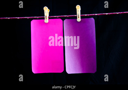 Rosa e viola appendere carta su sfondo nero Foto Stock