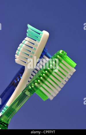 Tre gli spazzolini da denti sono su sfondo blu Foto Stock