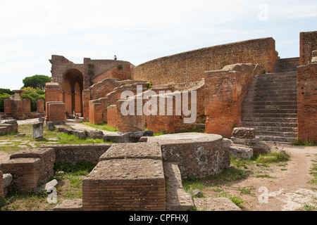 Il teatro e le colonne da Decumanus presso l'antico porto romano rovina città di Ostia vicino Roma. Foto Stock