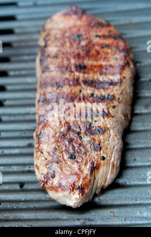 Primo piano della succulenta bistecca di fianco la cottura sul barbecue Foto Stock