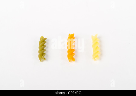 Tre colorate di pasta cruda spire in una riga Foto Stock