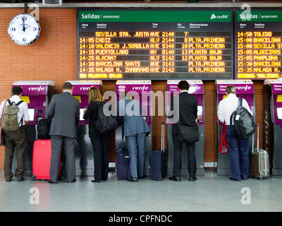 Persone che acquistano biglietti presso la stazione ferroviaria di Atocha di Madrid in Spagna Foto Stock