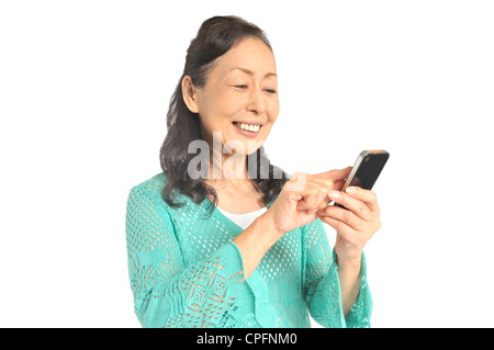 Senior donna utilizza lo smartphone Foto Stock