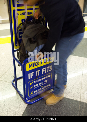 Persona che cercava di mettere nello zaino in Ryanair limite di dimensione Foto Stock