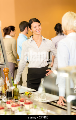 Caffetteria pranzo due colleghi di ufficio in chat attendere il cibo che serve la coda Foto Stock