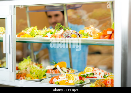 Caffetteria display alimentare giovane scegliere insalata fresca uno stile di vita sano Foto Stock