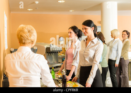 Caffetteria donna pagare al cassiere tenere portagiornali di alimenti freschi Foto Stock