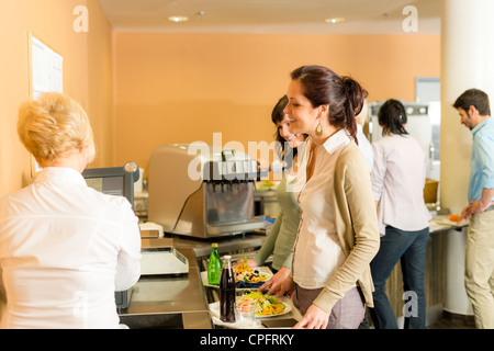 Caffetteria donna pagare al cassiere tenere portagiornali di alimenti freschi Foto Stock