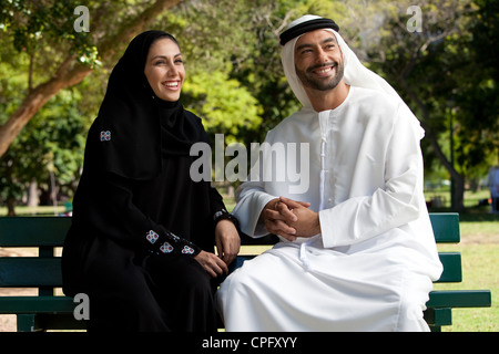 Arab giovane seduto presso il parco, sorridente. Foto Stock