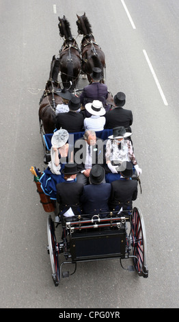 Elegantemente vestito di persone in sella ad una carrozza trainata da cavalli, Ascot, Regno Unito Foto Stock