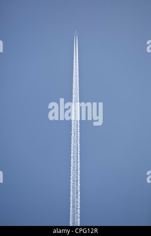 Jet sentieri di vapore attraverso un cielo blu, London, England, Regno Unito Foto Stock
