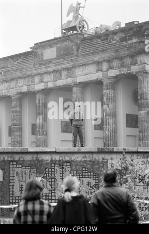 Una guardia di confine durante l'apertura del muro di Berlino alla Porta di Brandeburgo, Berlino, Germania Foto Stock