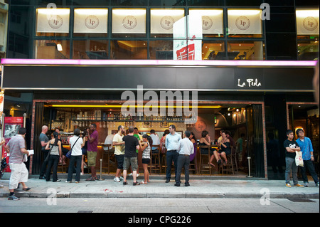 Gli espatriati, turisti, stranieri e gente del posto al di fuori di un affollato ristorante e bar di Soho, Hong Kong, Cina. Foto Stock