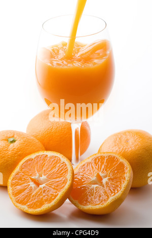 Riempimento di succo di vetro con arance Foto Stock