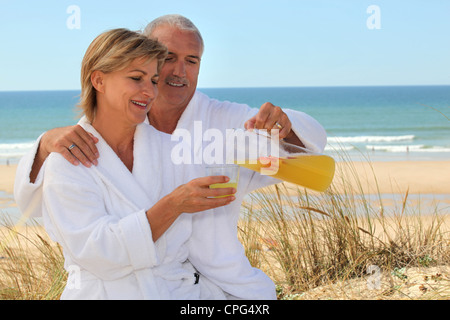 Matura in accappatoio sulla spiaggia Foto Stock