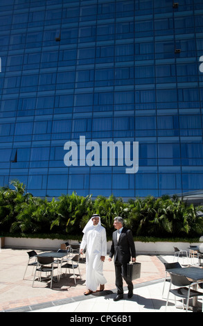 Imprenditore arabo e imprenditore occidentale a piedi nella parte anteriore dell'edificio degli uffici. Foto Stock