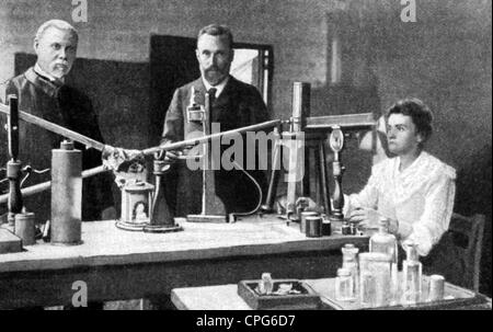 Curie Marie, 7.11.1867 - 4.7.1934, chimico e fisico francese, di origine polacca, a mezza lunghezza, presso il laboratorio, con il marito Pierre, assistent Edison Petit, circa 1905, Foto Stock