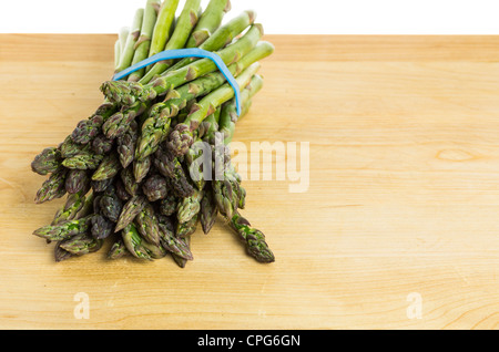 Mazzetto di asparagi spears con banda blu sul tavolo Foto Stock