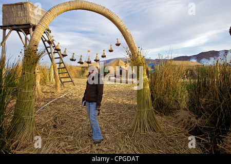 Turistico a Uros isola, isole galleggianti di Uros persone, tradizionali barche reed e reed case, il lago Titicaca, Perù Foto Stock