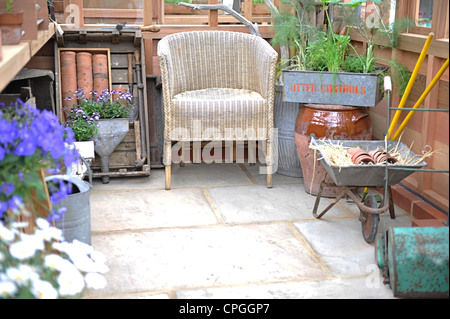 Visualizza Potting Shed della RHS Chelsea flower show 2012 con attrezzi da giardino, sedia di vimini Foto Stock