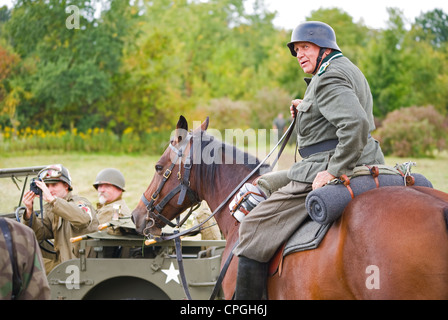 Soldato tedesco sul cavallo marrone film di guerra teatro sotto il cielo aperto acciaio casco Foto Stock