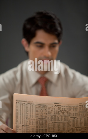 Giovane imprenditore quotidiano di lettura Foto Stock