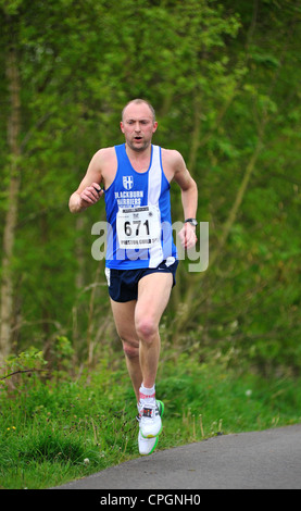 Runner maschio in competizione in una corsa su strada Foto Stock