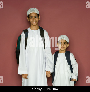 Fratelli che trasportano borse tracolla, ritratto, sorridente Foto Stock