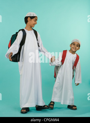 Fratelli che trasportano borse tracolla, ritratto, sorridente Foto Stock